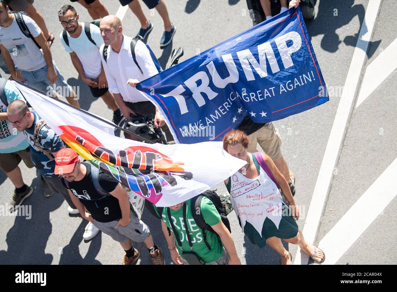 Stuttgart, Germany. 08th Aug, 2020. Participants walk during a demonstration against the Corona measures under the motto 'Call of the drums' with a flag on the 'Trump' and a flag on the 'Love wins' stands next to each other. The demonstration was registered by a private person. Credit: Sebastian Gollnow/dpa/Alamy Live News Stock Photo