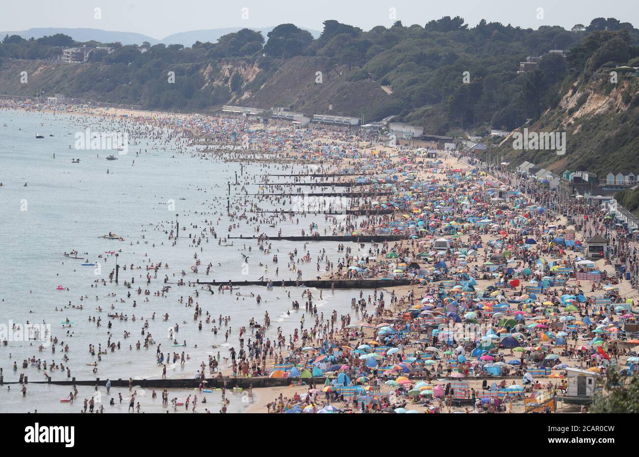 People enjoy the hot weather on Durley and Alum Chine beaches in Dorset. Stock Photo