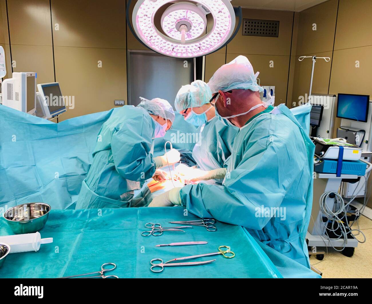 in a large operating theatre a surgical operation is performed by two ...