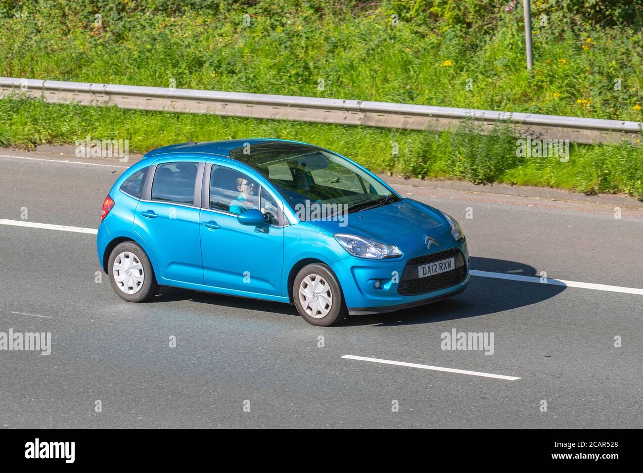 2012 blue Citroën C3 Airdream Vtr+ E-HDI S-; Vehicular traffic moving vehicles, cars driving vehicle on UK roads, motors, motoring on the M6 motorway highway network. Stock Photo