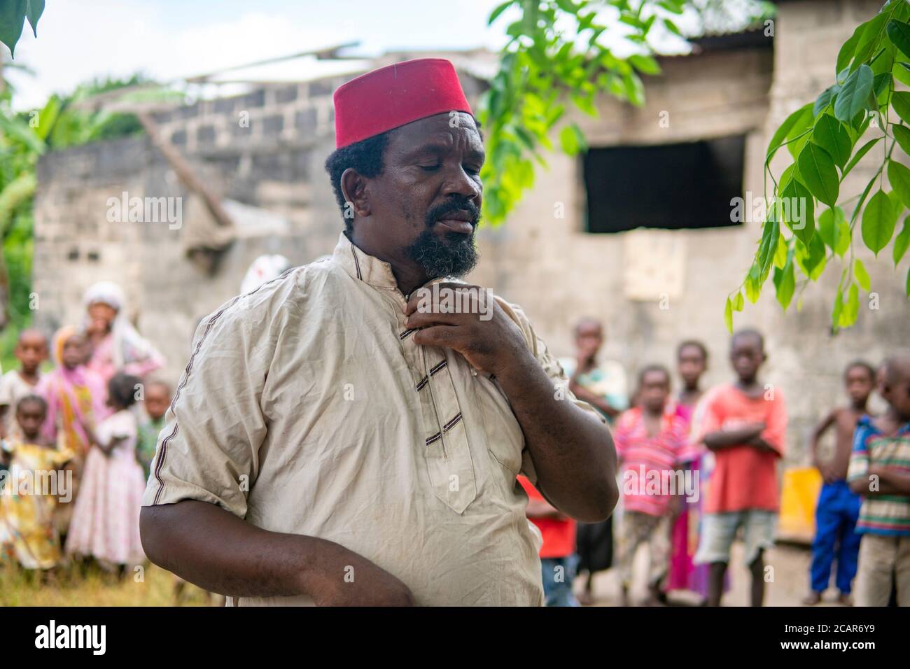 An African Older Man, The Mayor of His Village in Red Muslim Taqiyyah Hat and White Dress. Small Remote Village in Tanzania, Pemba island, Zanzibar Stock Photo