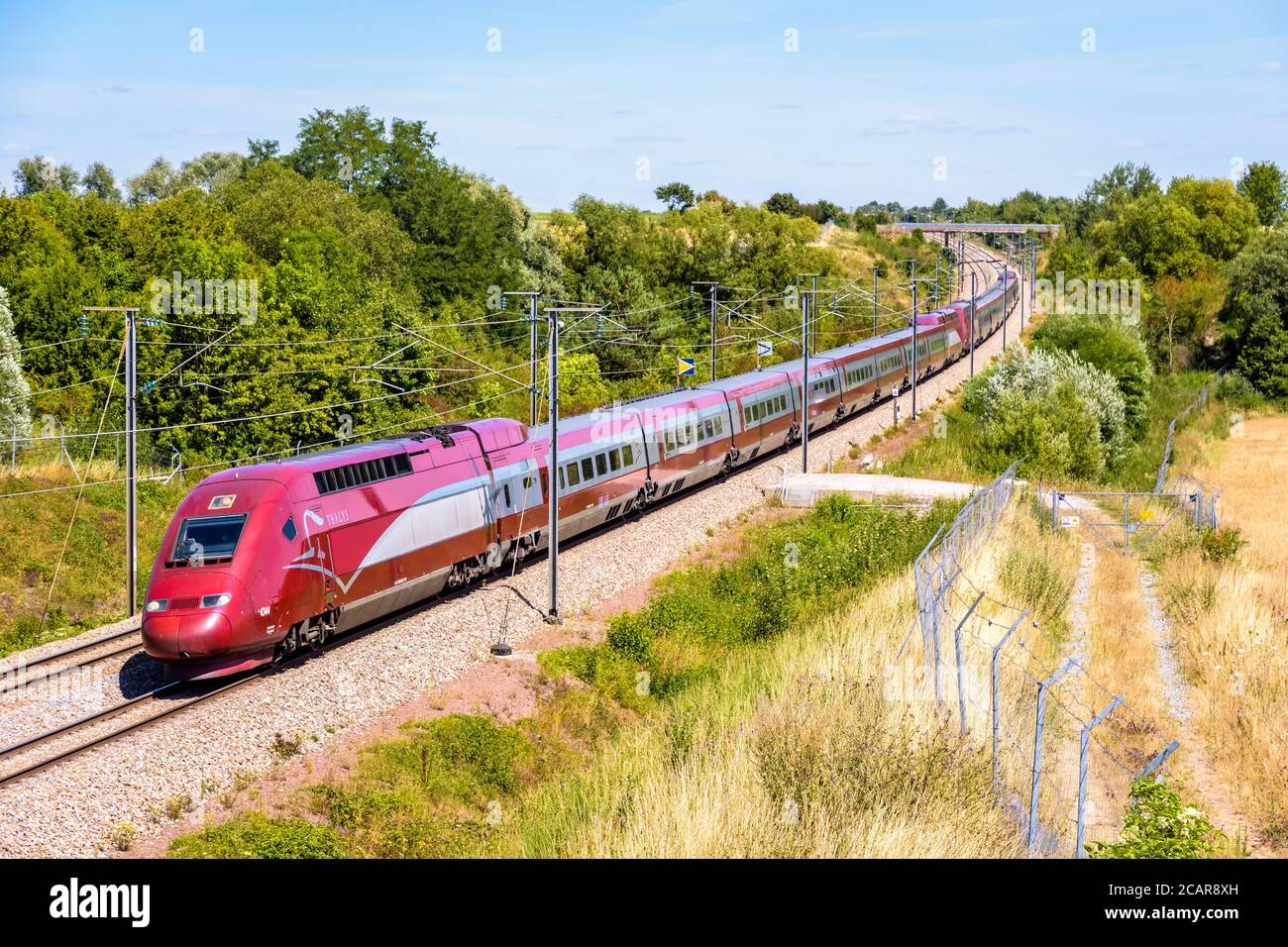A Thalys high speed train is driving from Brussels to Paris on the LGV Nord, the North European high speed railway line, in the french countryside. Stock Photo