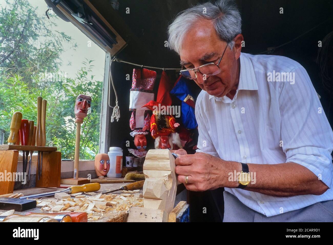 Master puppet maker John Haynes carving a Mr Punch head in his studio ...