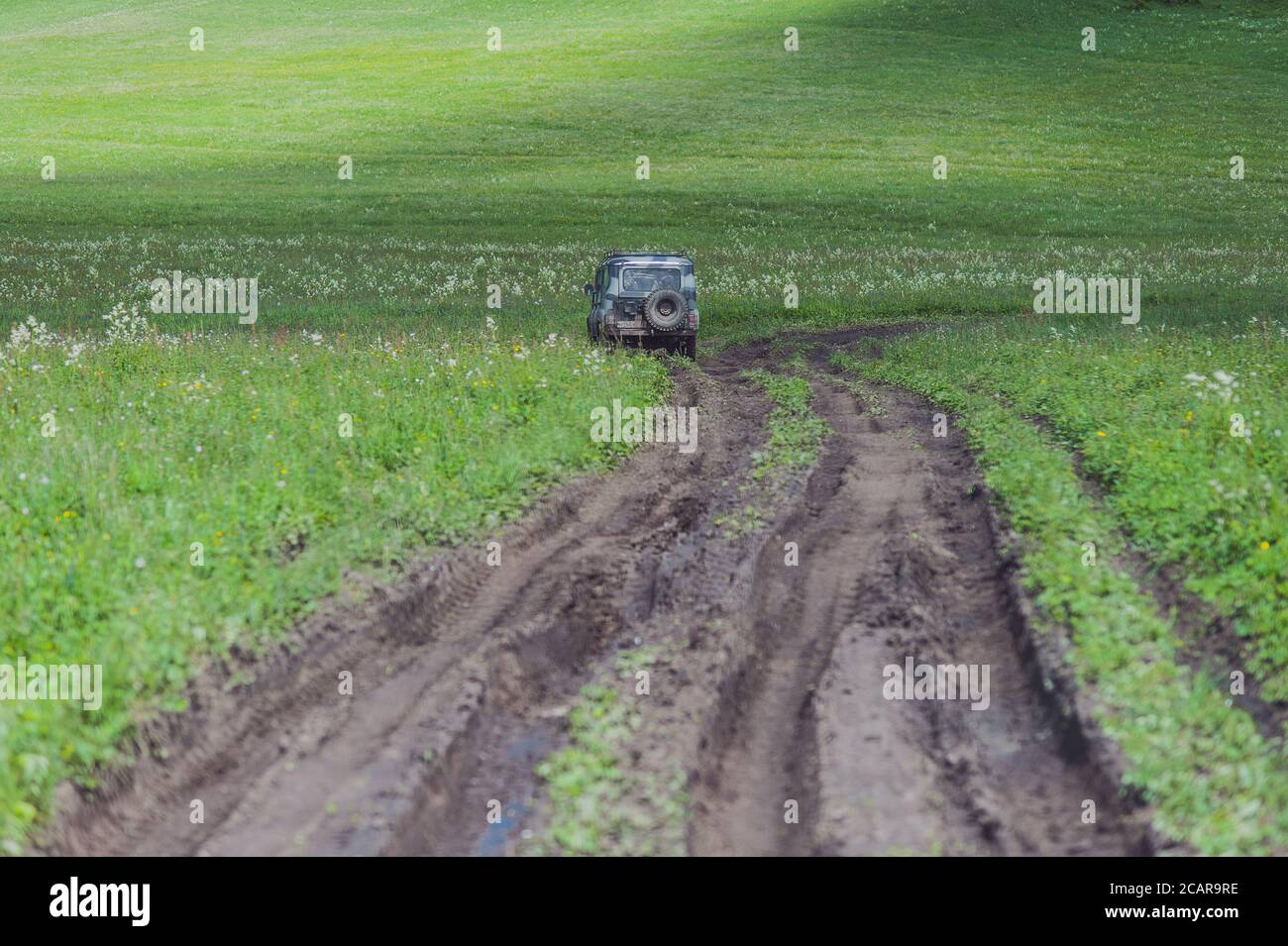 Car drives on mud road in Altai Mountains Stock Photo
