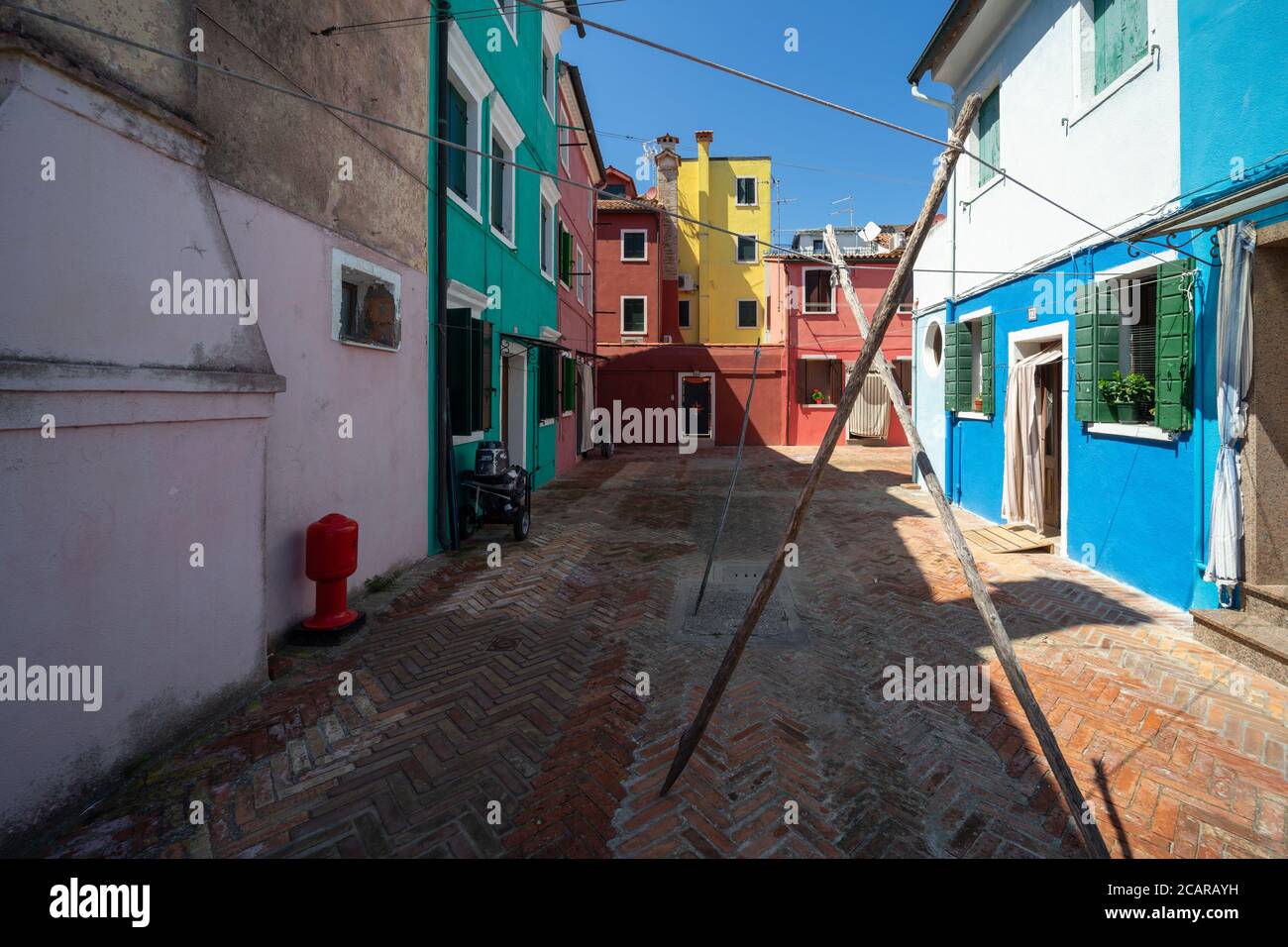 Burano island, Venetian Lagoon, Venice, Italy, a small square with the typical coloured fisherman homes of the village Stock Photo