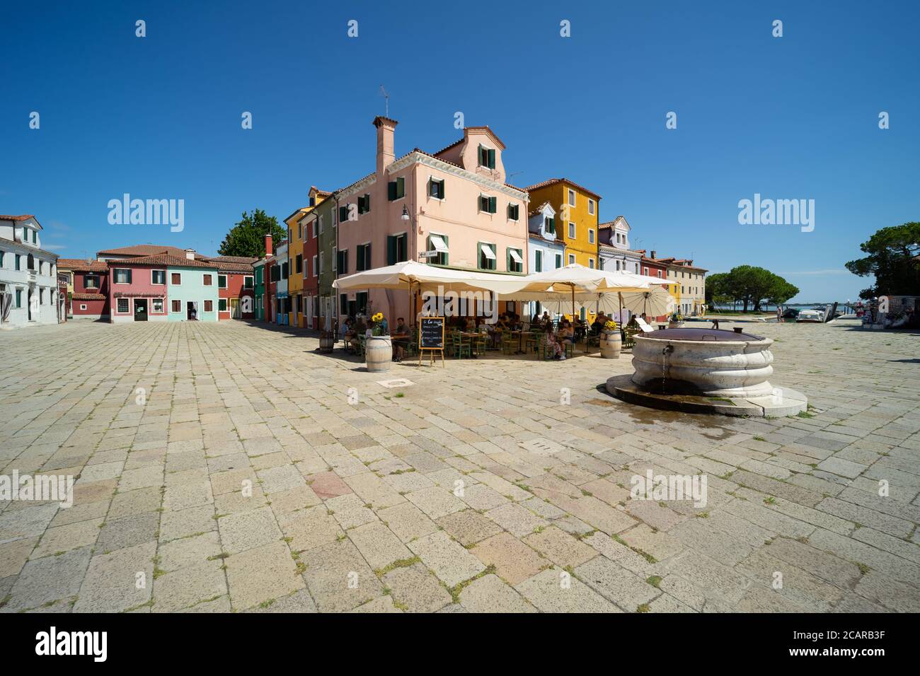 Burano island, Venetian Lagoon, Venice, Italy, Piazza Galuppi square in the town historic centre with ancient water wall Stock Photo