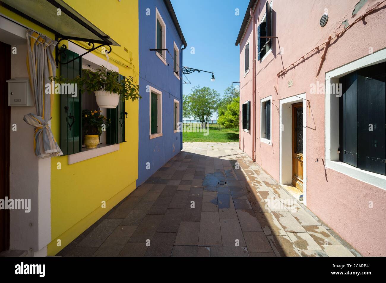 Burano island, Venetian Lagoon, Venice, Italy, narrow street between the typical coloured homes of the town centre Stock Photo