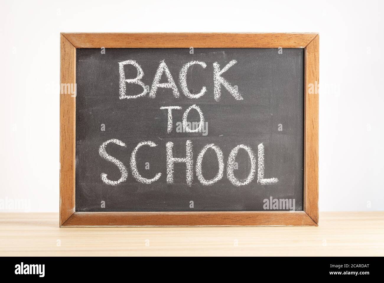 Back to school concept. Chalkboard with handwritten text on table Stock Photo