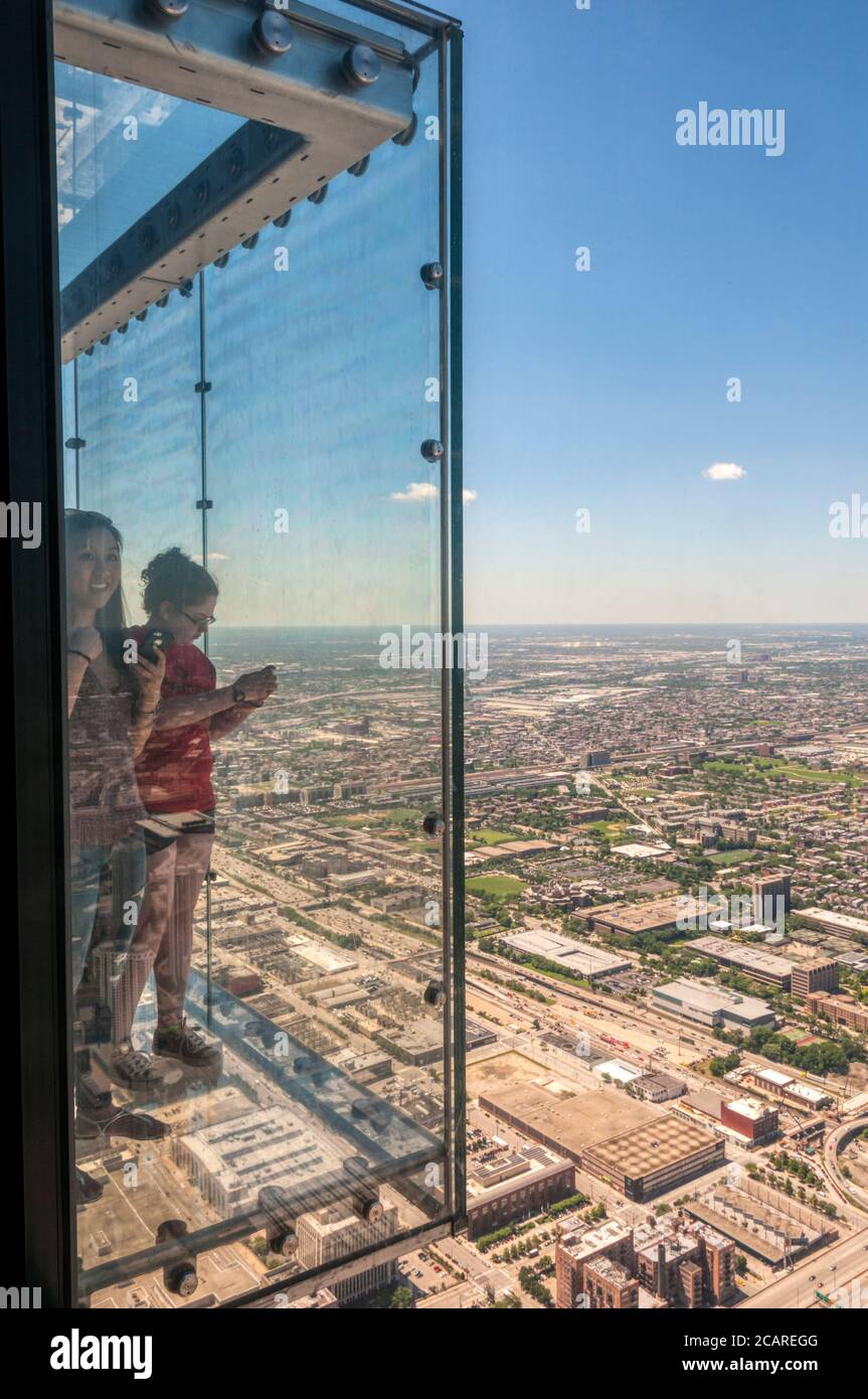 People on the glass balcony to the observation deck of the Willis Tower, with an aerial view of Chicago. Stock Photo
