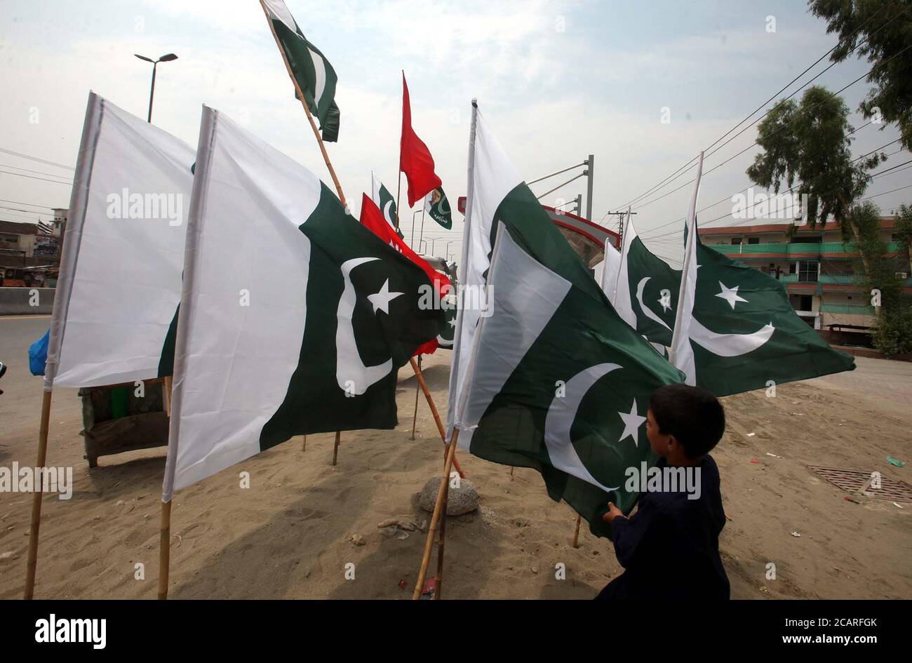 Pakistan flags and buntings are being selling on roadside stall in connection of Independence Day celebration coming ahead, at Ring road in Peshawar on Saturday, August 8, 2020. Stock Photo