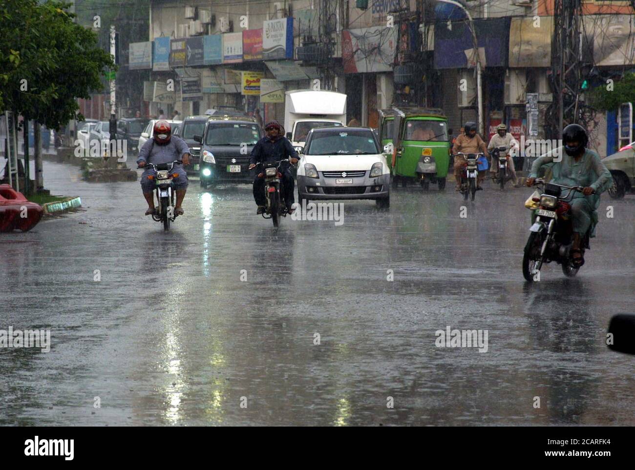 Commuters are passing through a road during heavy downpour of monsoon season, at Shimla Hill in Lahore on Saturday, August 8, 2020. Stock Photo