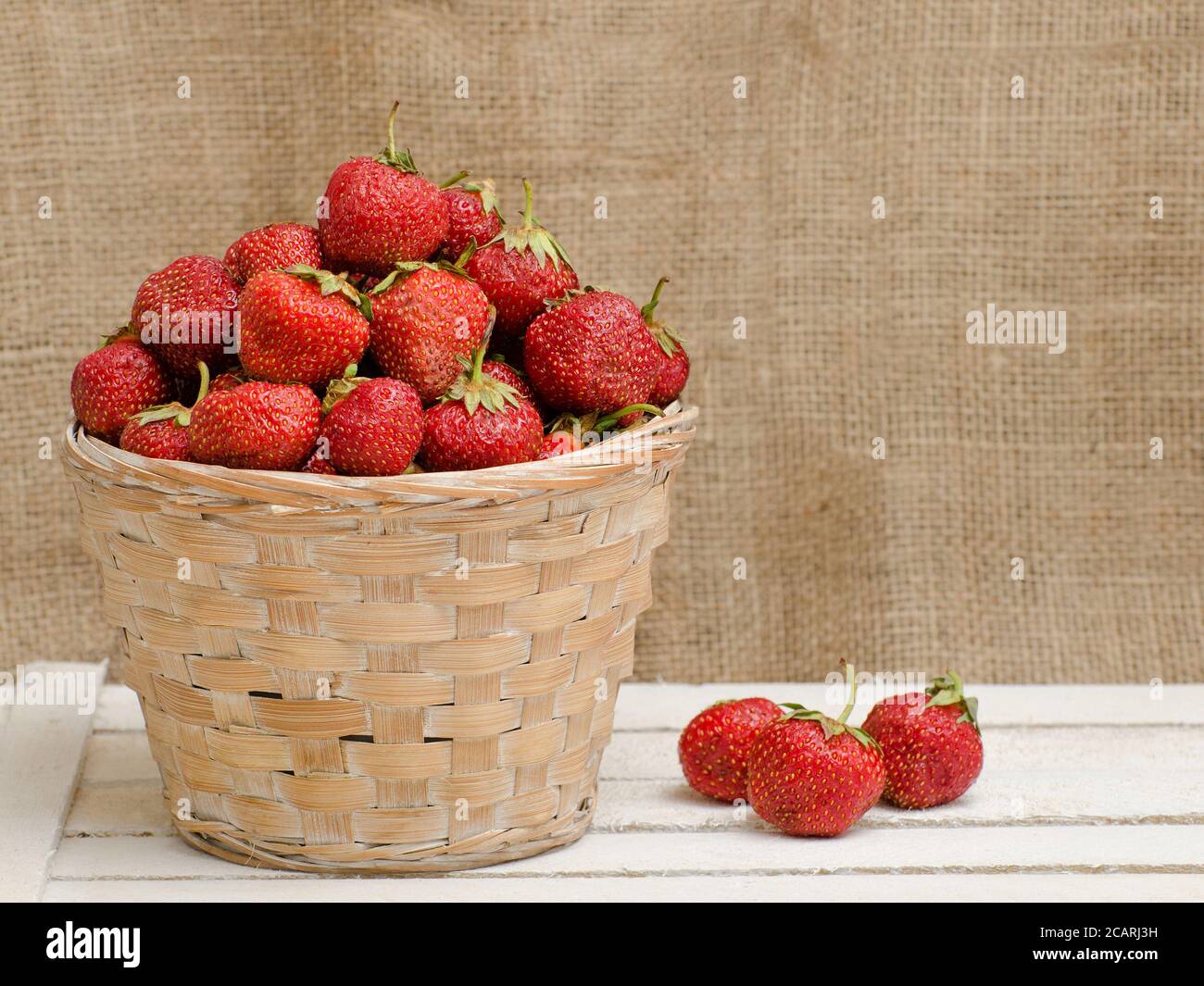 Basket of ripe strawberries on a wooden background Stock Photo - Alamy