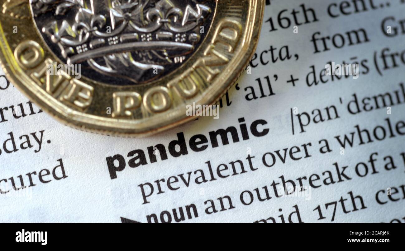 BRITISH ONE POUND COIN WITH DICTIONARY DEFINITION OF WORD PANDEMIC RE THE ECONOMY CORONAVIRUS COVID-19   GLOBAL DISEASE ETC UK Stock Photo