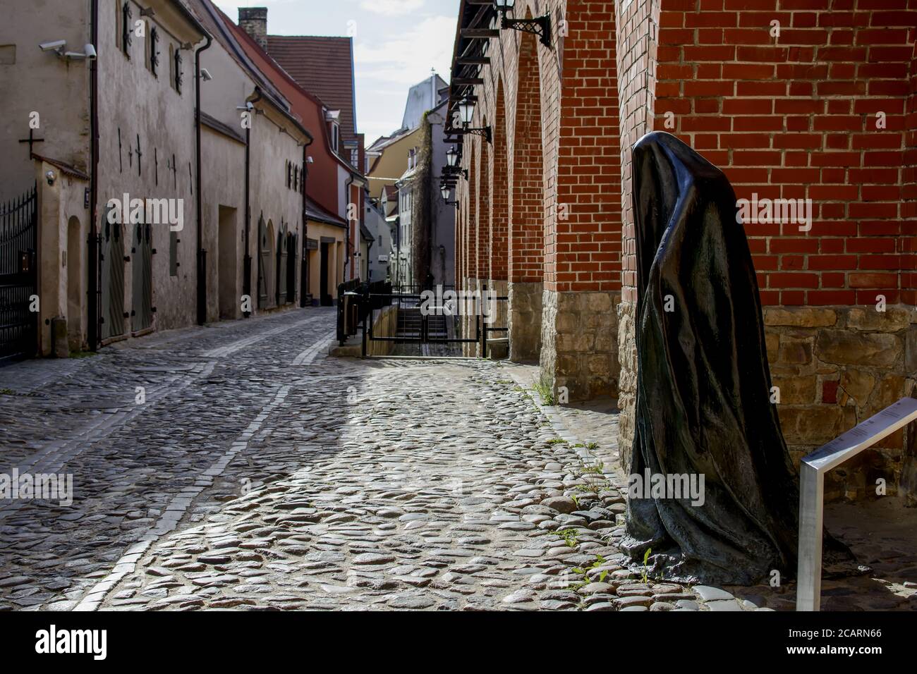 The Ghost bronze sculpture by Ieva Rubeze in Old Town near medieval defence wall Stock Photo