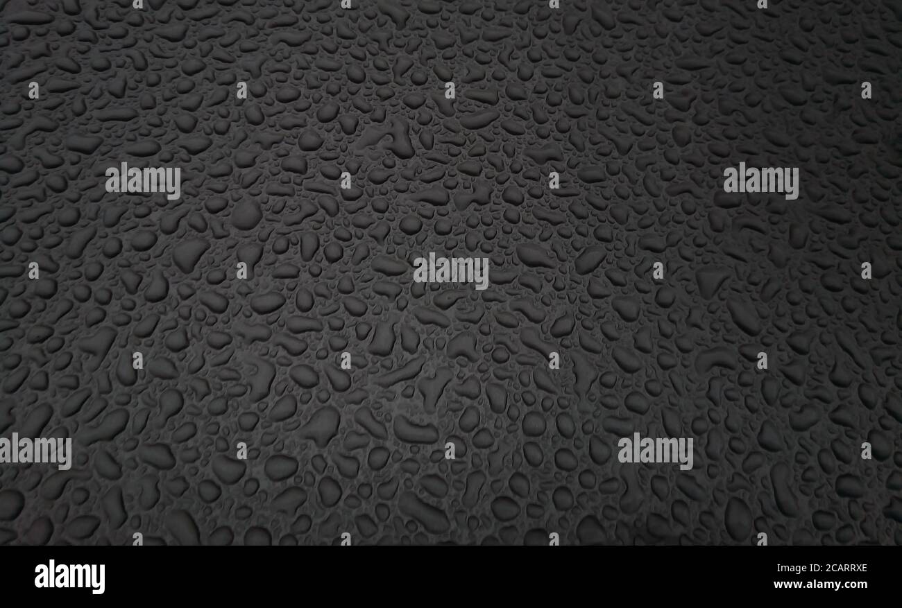 Beautiful background texture of rain water drops on grey black metal surface. Beautiful backgrounds. Drops of water on a color background. Dark grey. Stock Photo