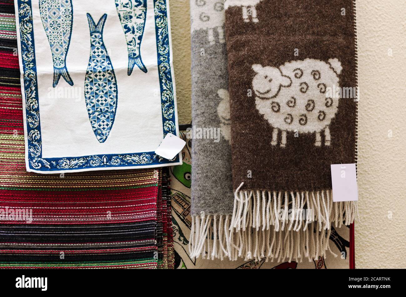 many traditional portuguese wool scarves and cotton cloth with sheeps and sardines decorations Stock Photo
