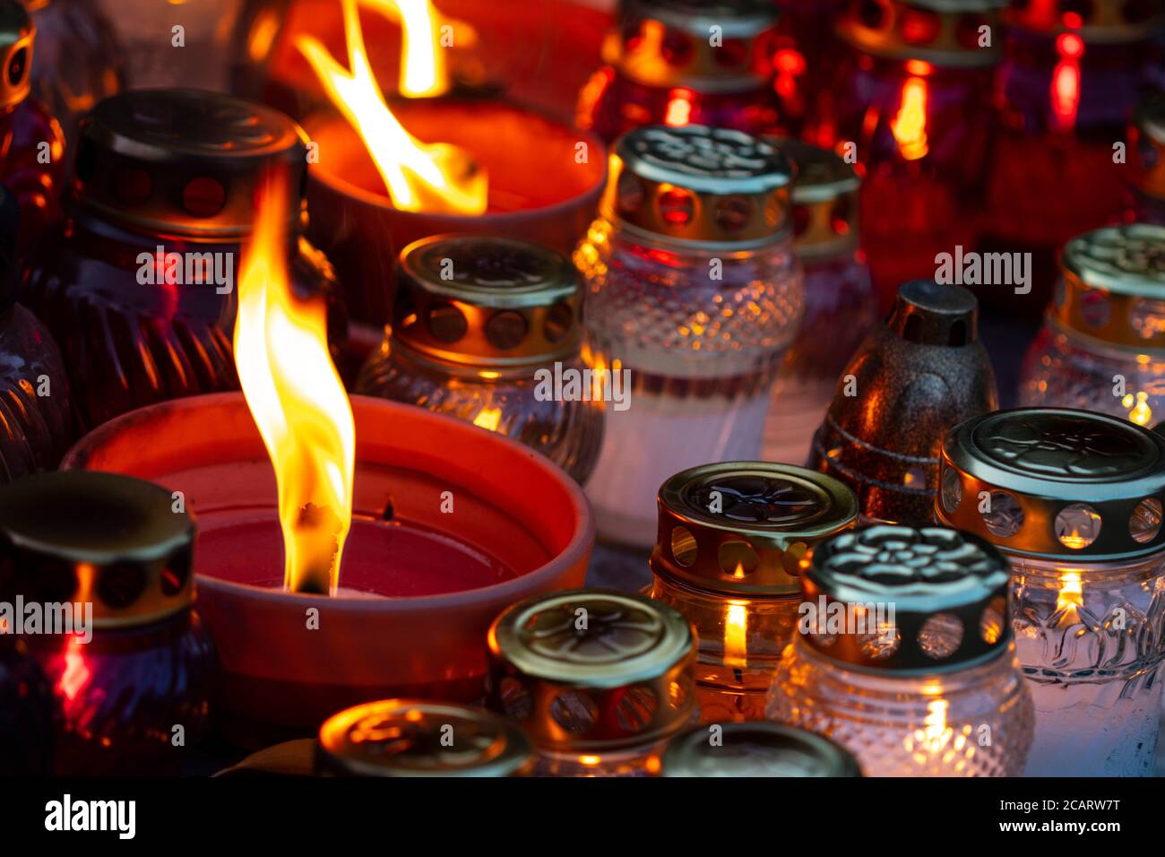 Many different kind of burning grave candles during All Souls' Day Stock Photo