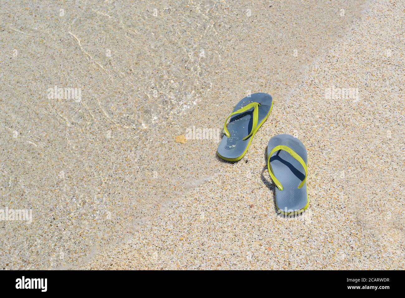 flip flops on a sandy beach by the foreshore Stock Photo - Alamy