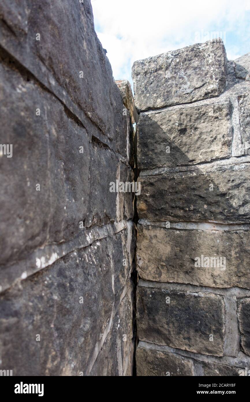 vertical crack in an old stone wall Stock Photo