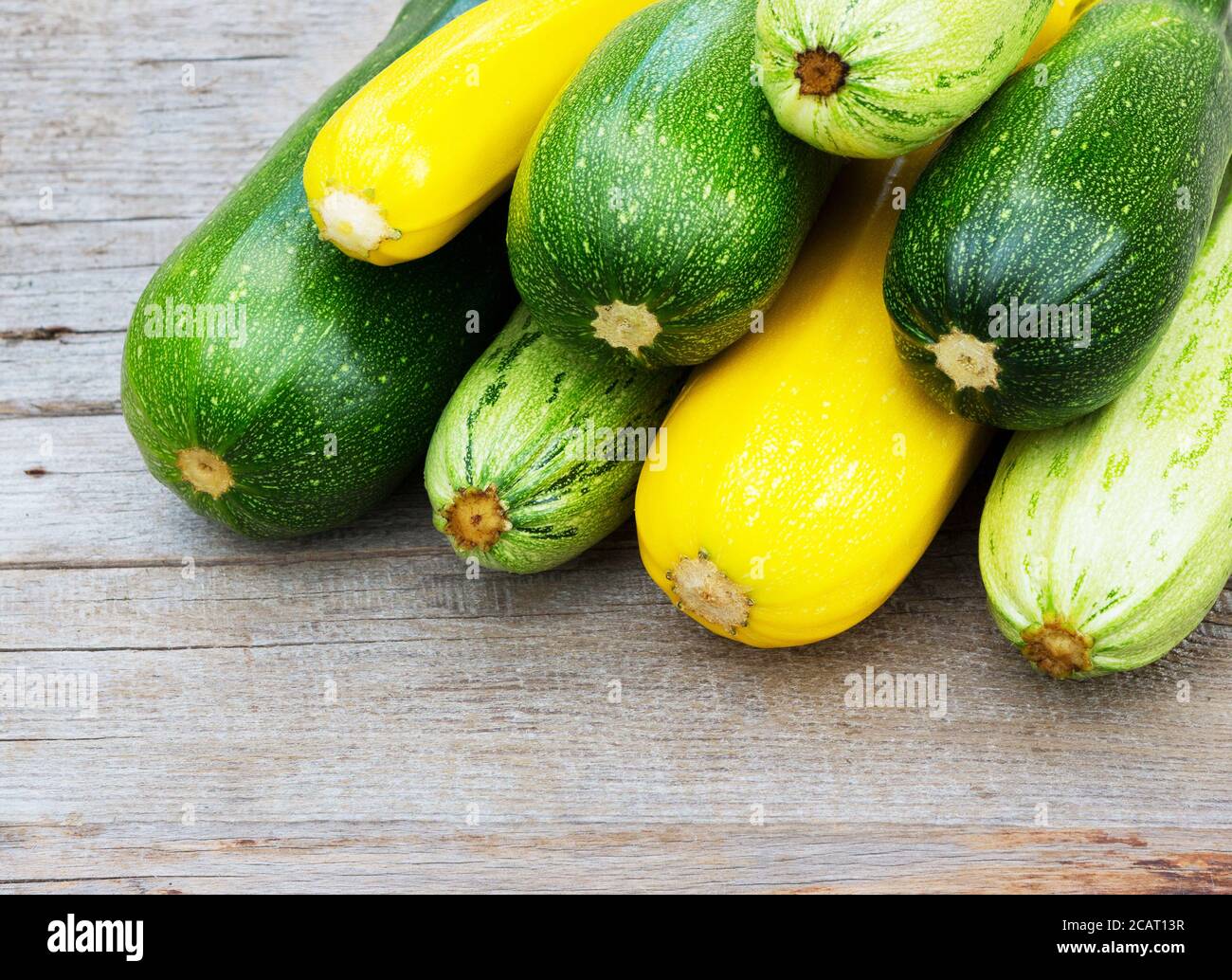 Zucchini on wooden background. Yellow and green zucchini. Vegetable