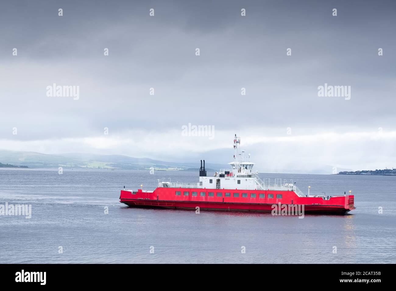 Red ship ferry transport over sea under dark storm clouds Stock Photo