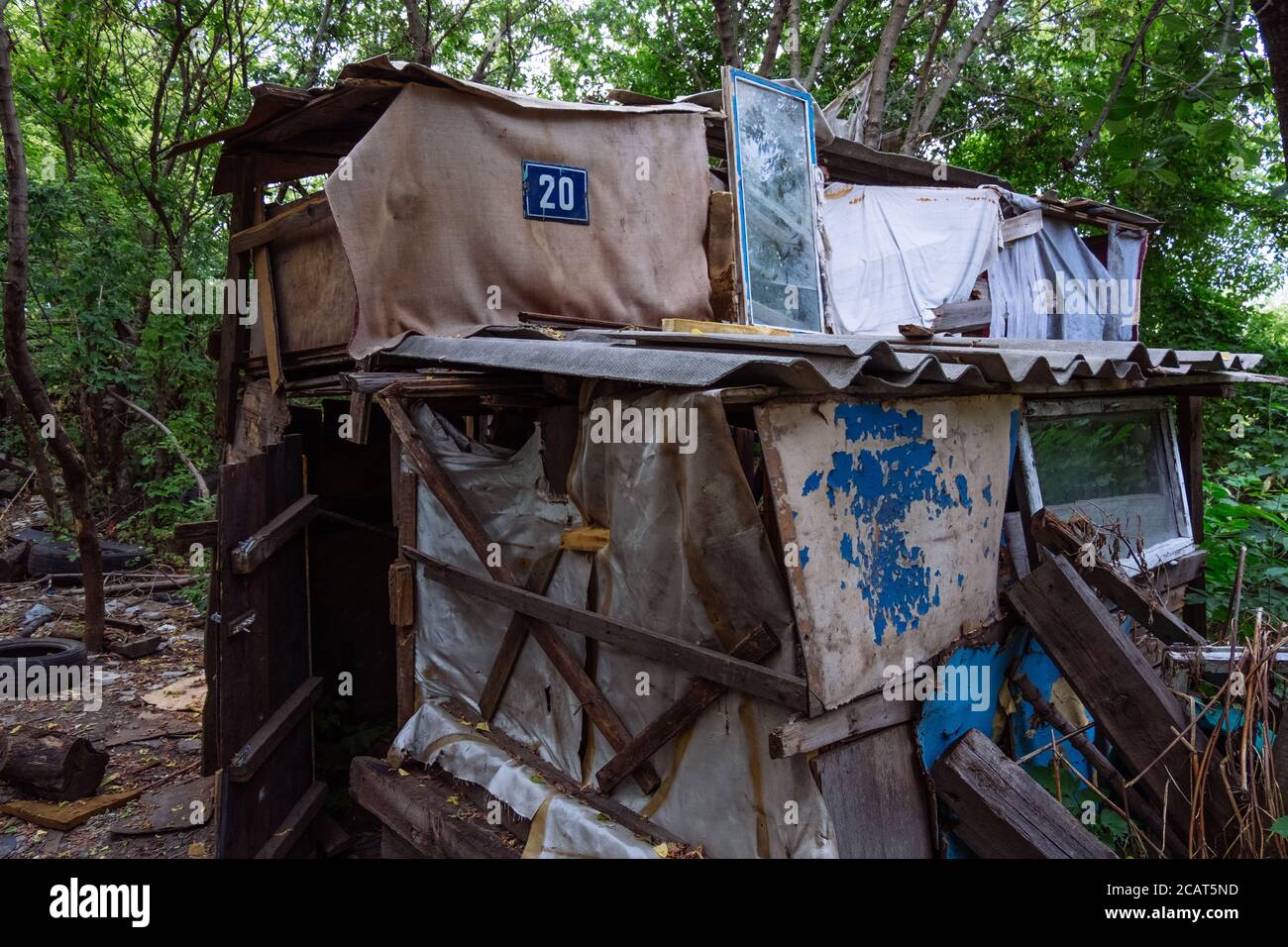 Homeless dweling. Small habitation made from garbage in dirty littered forest Stock Photo