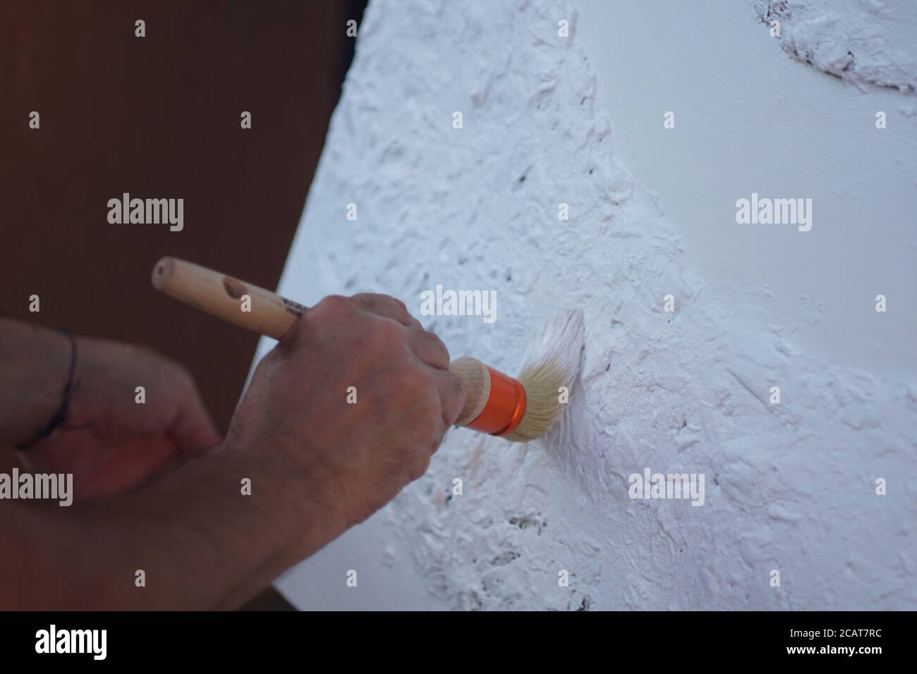 Closeup of a professional artist paint the canvas with white paint