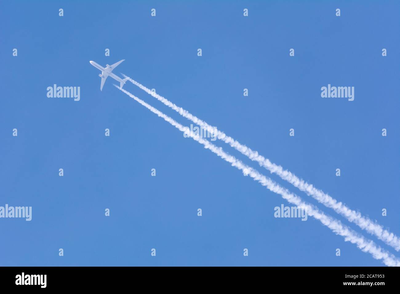 Contrails from a jet aircraft against a clear blue sky Stock Photo