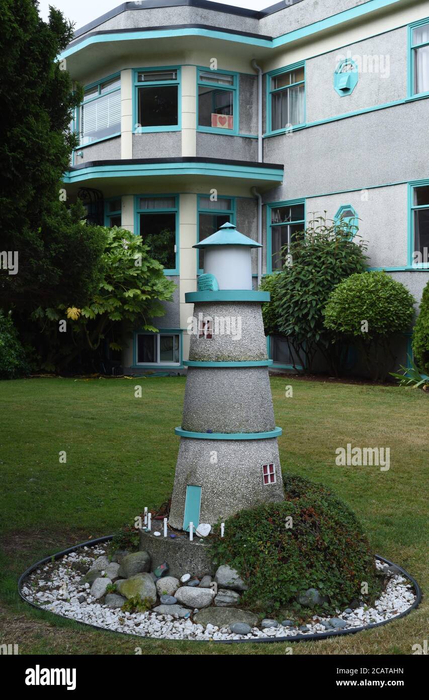 A model lighthouse decorates the lawn outside an apartment building in Victoria, British Columbia, Canada on Vancouver Island. Stock Photo