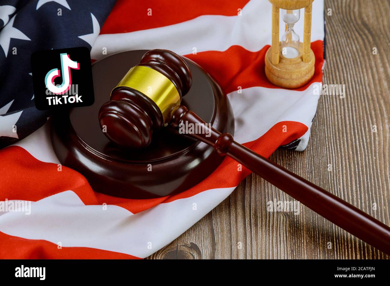 WASHINGTON D.C., USA - AUGUST 05, 2020: Conflict between the President of the United States and the Chinese company tik tok on Justice gavel lawyers office symbol legal law with hourglass on United States flag Stock Photo