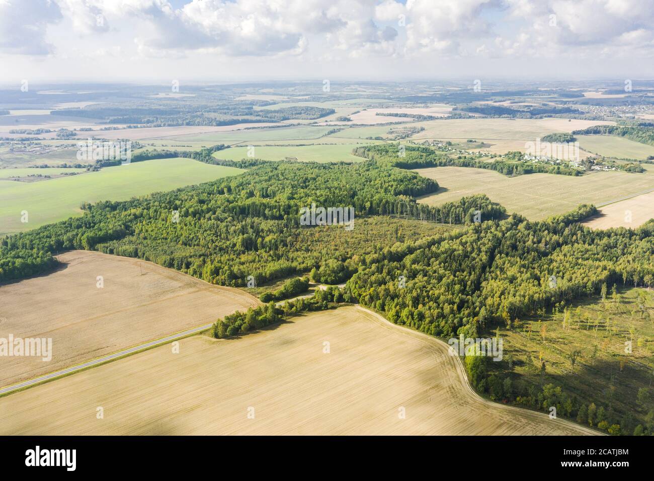 countryside farmland landscape on bright summer day. cultivated fields between forests. aerial photo from the drone Stock Photo