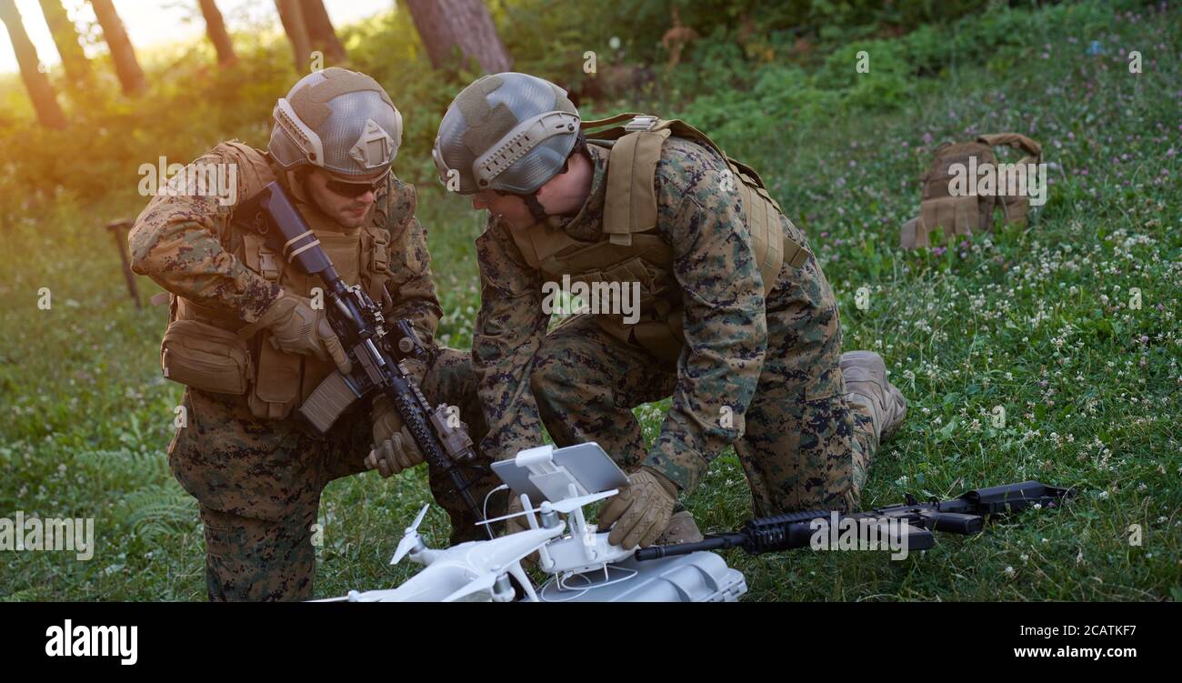 Modern Warfare Soldiers Squad are Using Drone for Scouting and Surveillance During Military Operation in the Forest. Stock Photo