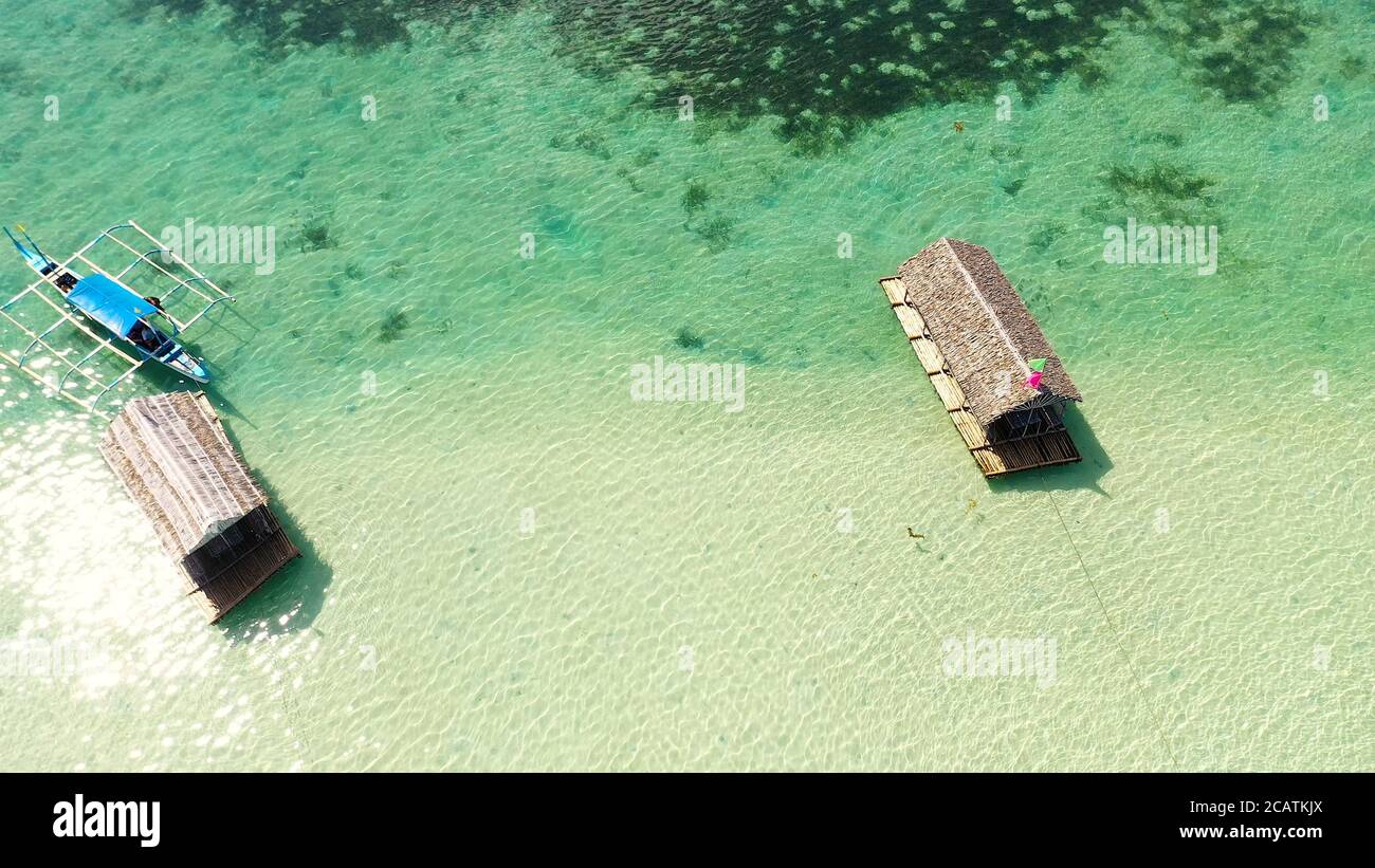 A floating native cottage on a sandbar in the tourist island of Caramoan in the Philippines. Summer and travel vacation concept. A lagoon with floating crotches, top view. Stock Photo