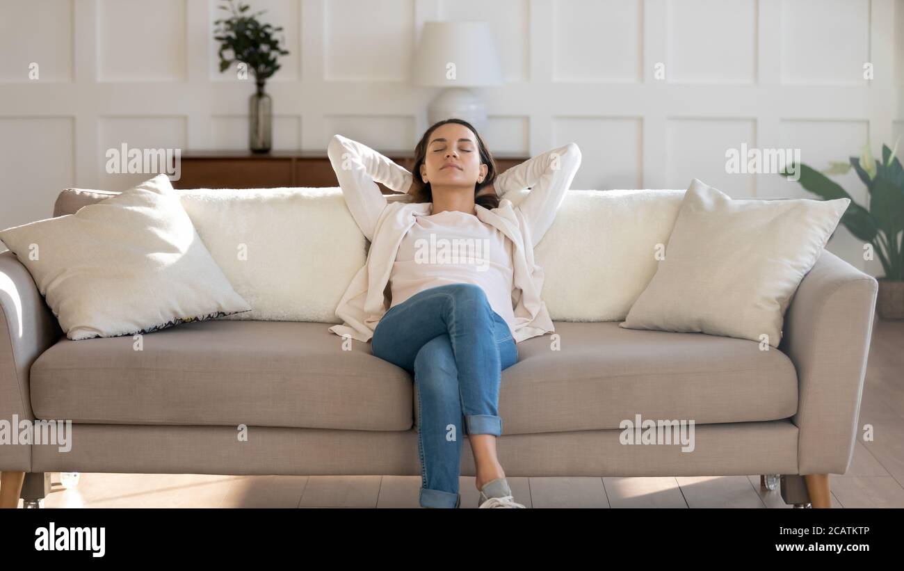 Relaxed young 30s woman sleeping on comfortable couch. Stock Photo