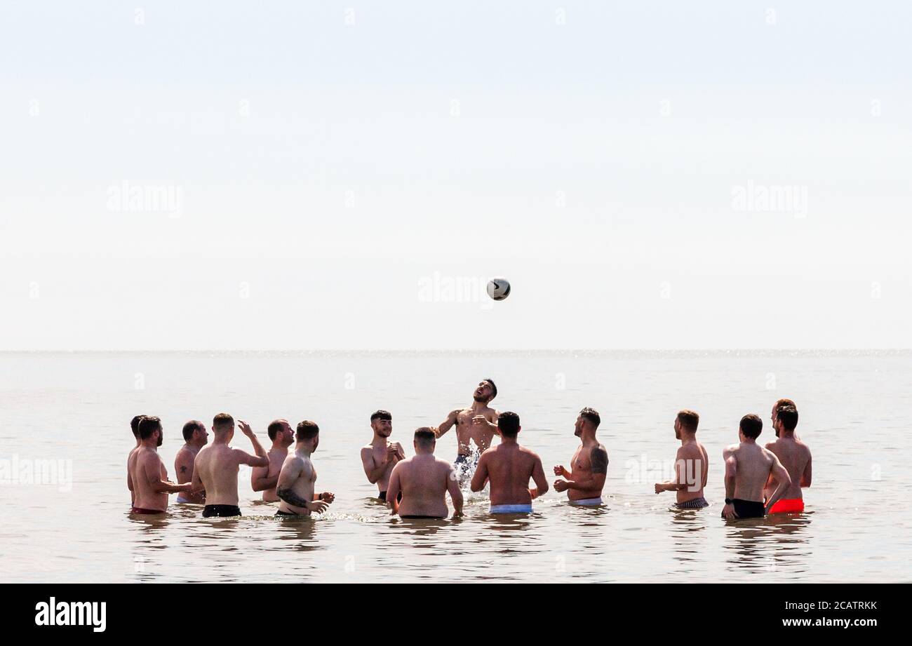 Claycastle, Cork, Ireland. 08th August, 2020. Players from Mayfield United senior soccer team, cool down after pre-season training session on a hot summers day with a game of head tennis in the sea at Claycastle, Co. Cork, Ireland.  - Credit; David Creedon / Alamy Live News Stock Photo