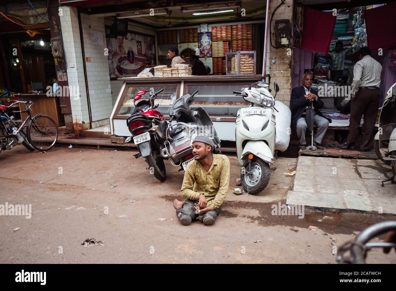 Agra / India - February 22, 2020: young indian man with physical problems asking for money sitting on the street Stock Photo