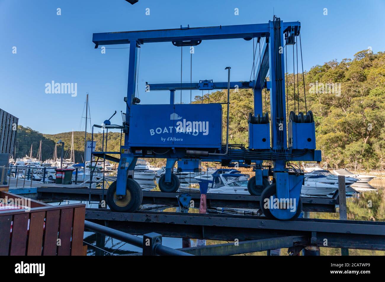 Boat lift System at Akuna Bay and Vessels moored at Marina background blur on a sunny winter afternoon Stock Photo