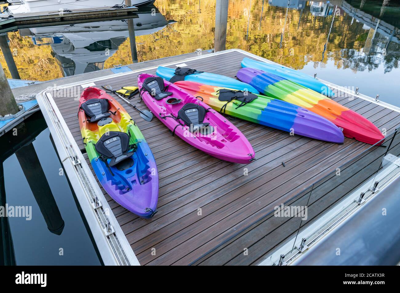 Colorful Kayaks at D'Albora Marinas Akuna Bay on a sunny winter afternoon Stock Photo
