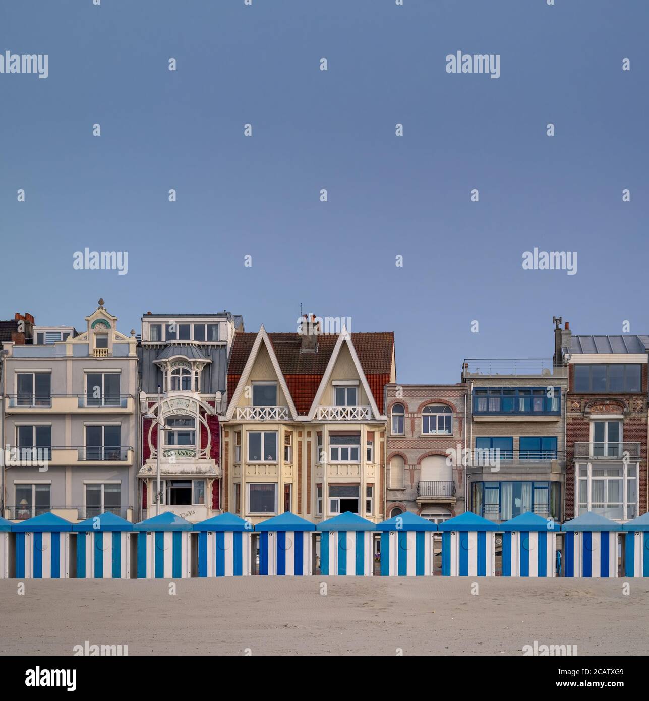 Blue and white striped beach huts against evening sky Stock Photo