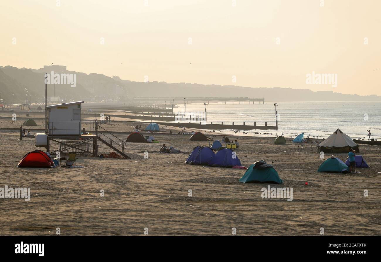 Tents pitched up on Bournemouth beach in Dorset as the sun rises. Stock Photo