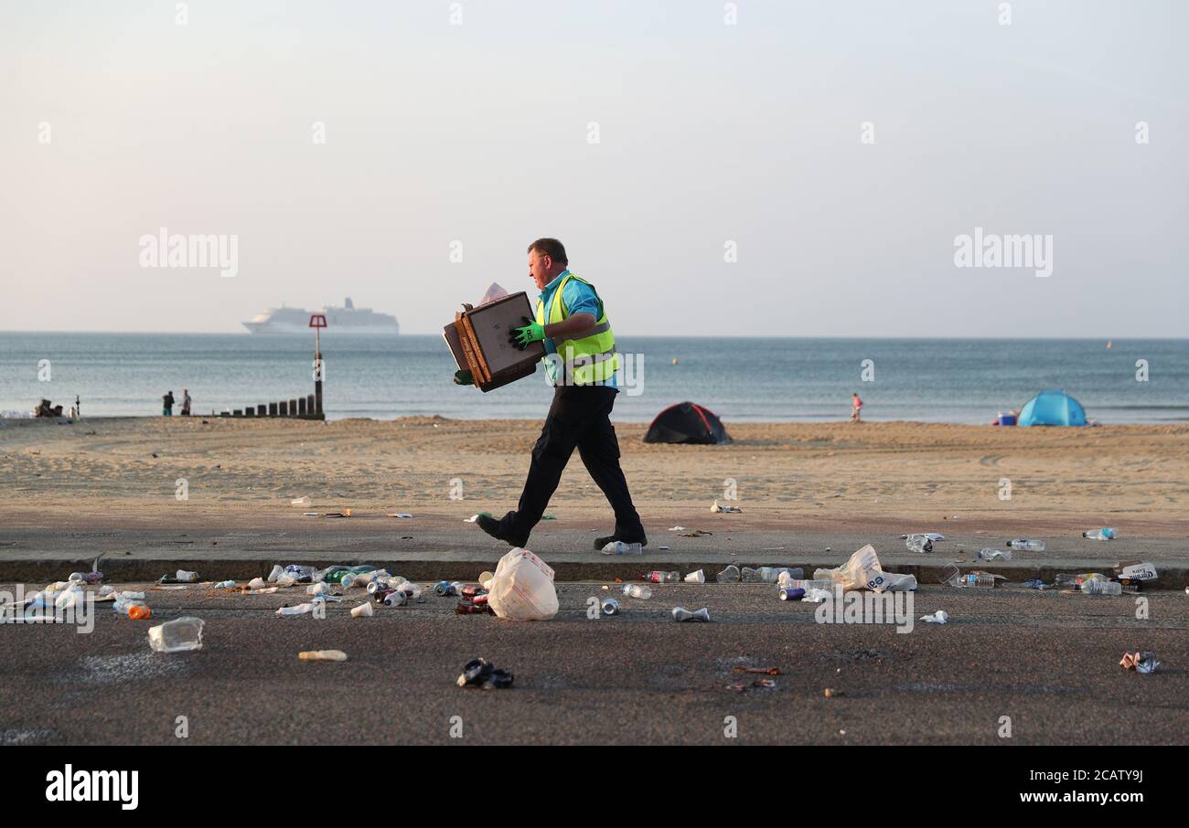 A member of BCP council cleans up excess waste that fell from bins that were emptied on
