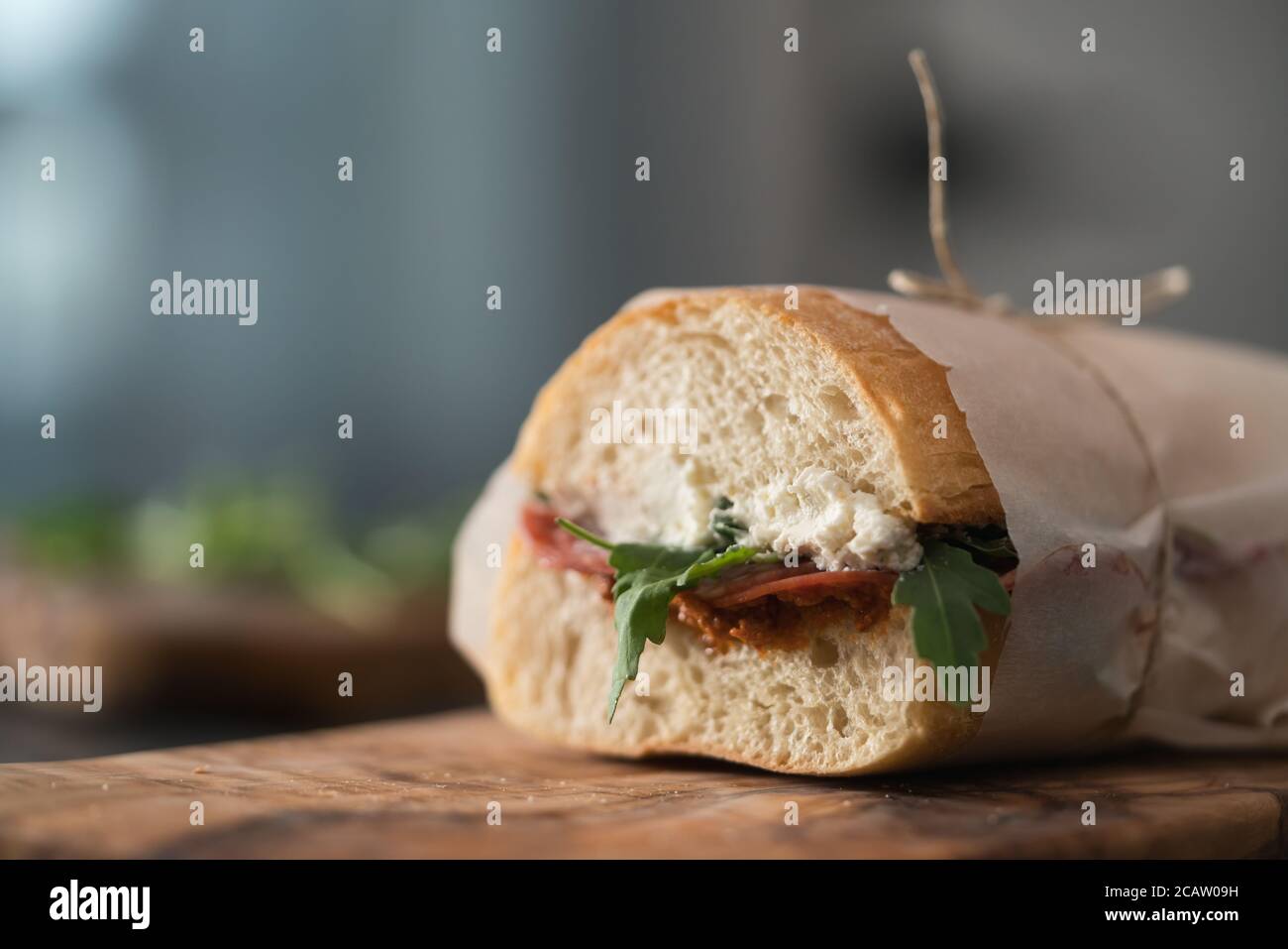 Ciabatta sandwich with salame, arugula, red pesto and cream cheese
