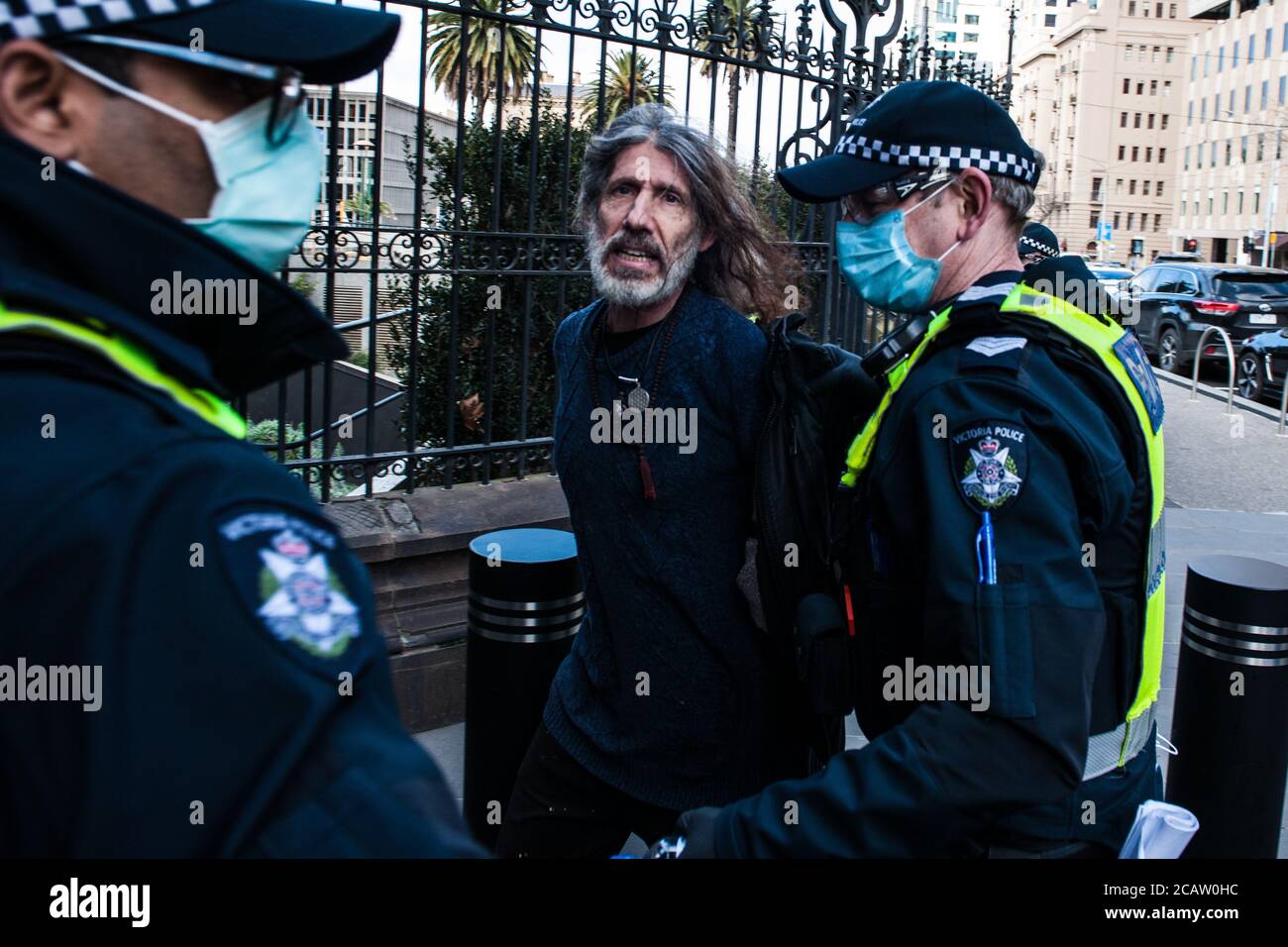 Melbourne, Australia 9 August 2020, some of the large number of Victorian Police Officers deployed to counter anti-mask protests, arrest a man for refusing to a mask outside of the State Parliament. Credit: Michael Currie/Alamy Live News Stock Photo