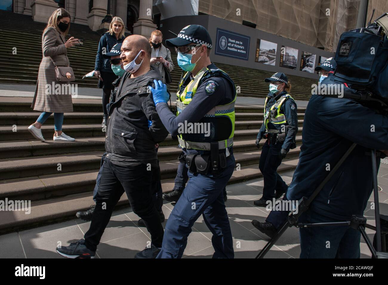 Melbourne, Australia 9 August 2020, some of the large number of Victorian Police Officers deployed to counter anti-mask protests, arrest a man for refusing to a mask outside of the State Parliament. Credit: Michael Currie/Alamy Live News Stock Photo