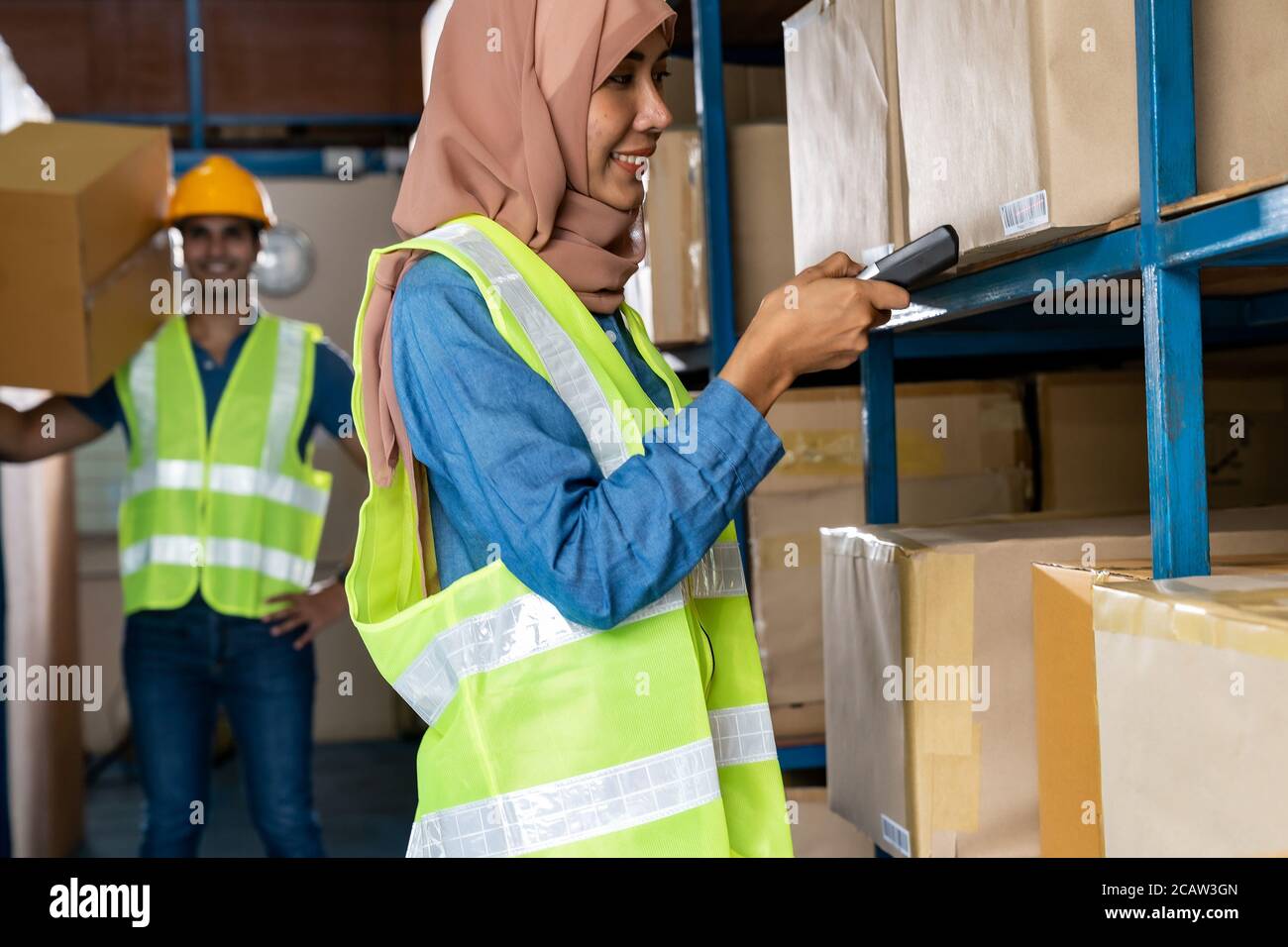 Asian Islam Muslim female warehouse worker do inventory with 