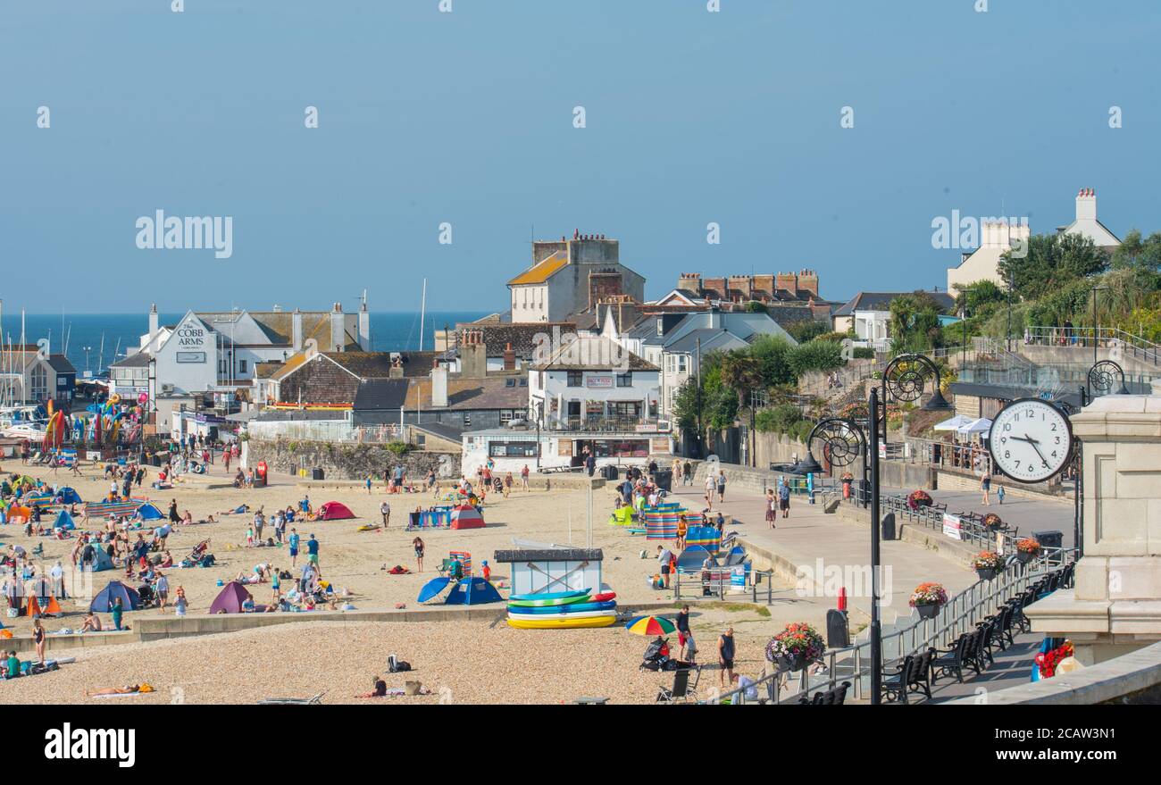 Lyme Regis, Dorset, UK. 9th August 2020. UK Weather: Holidaymakers and sunseekers hit the beach again to bask in scorching hot Sunday sunshine as the summer heatwave continues.  The beach was filling up by 9.30am. Credit: Celia McMahon/Alamy Live News. Stock Photo