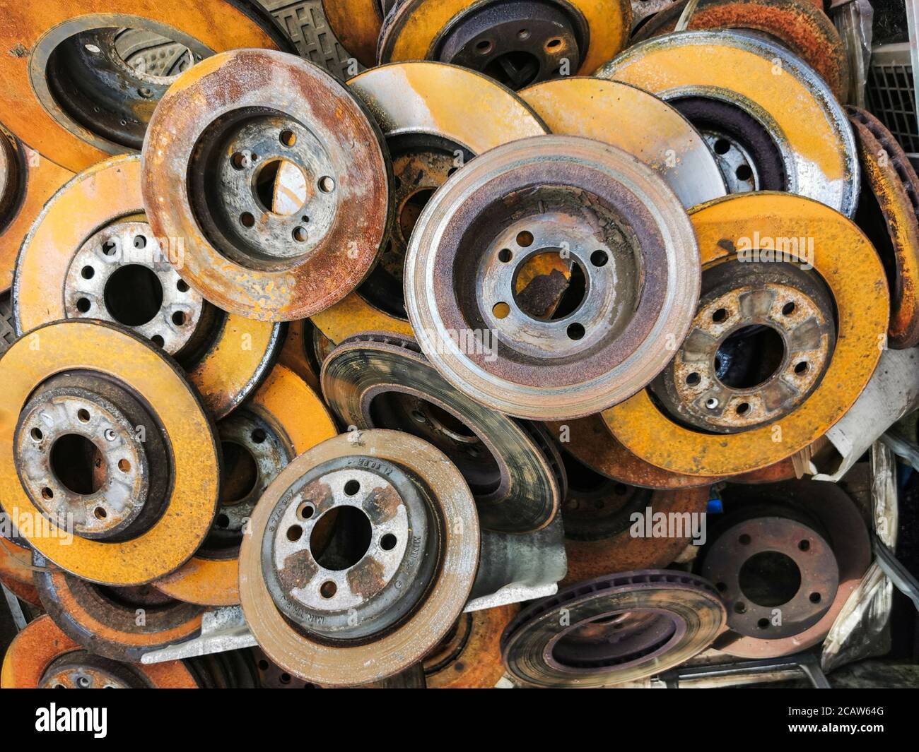 Used rusty car brake discs in a bin ready for recycling. Metal recycle and reuse is one of the main challenges of the modern world. Stock Photo