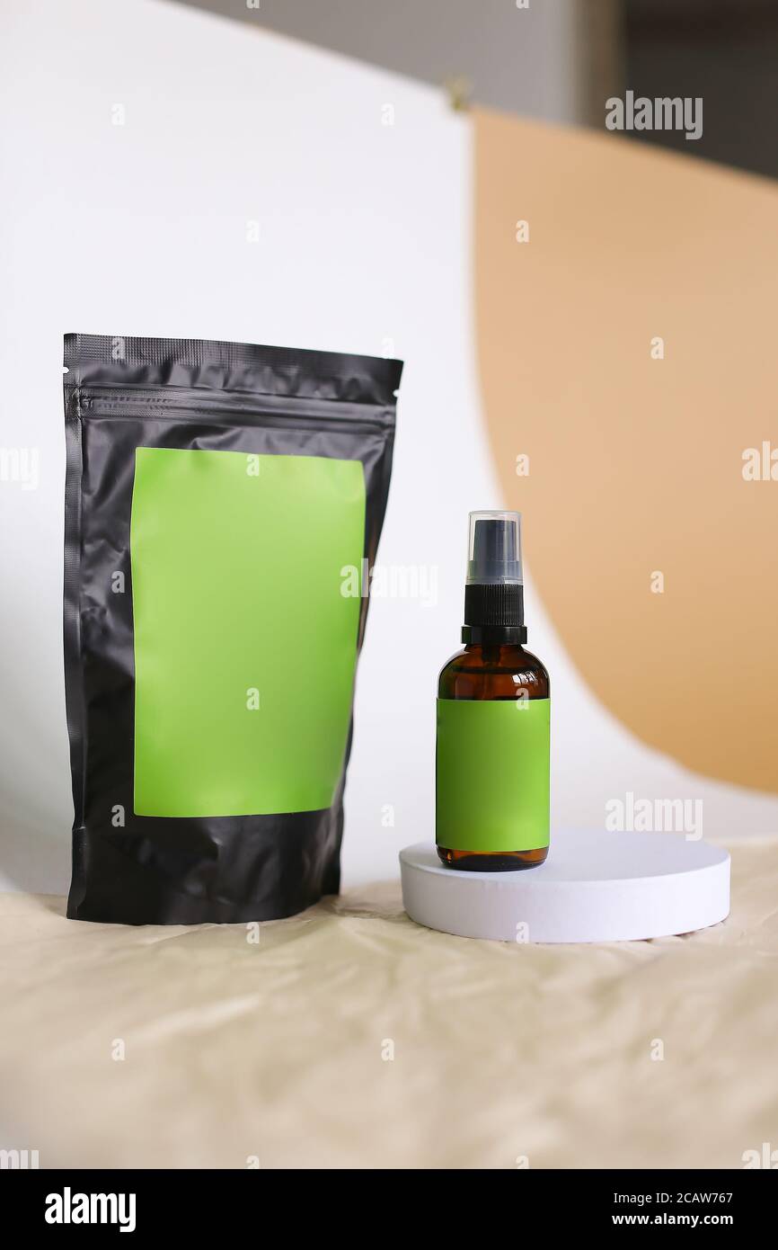 Close up doy pack and spray bottle with cosmetic product, green space for brand. Stock Photo