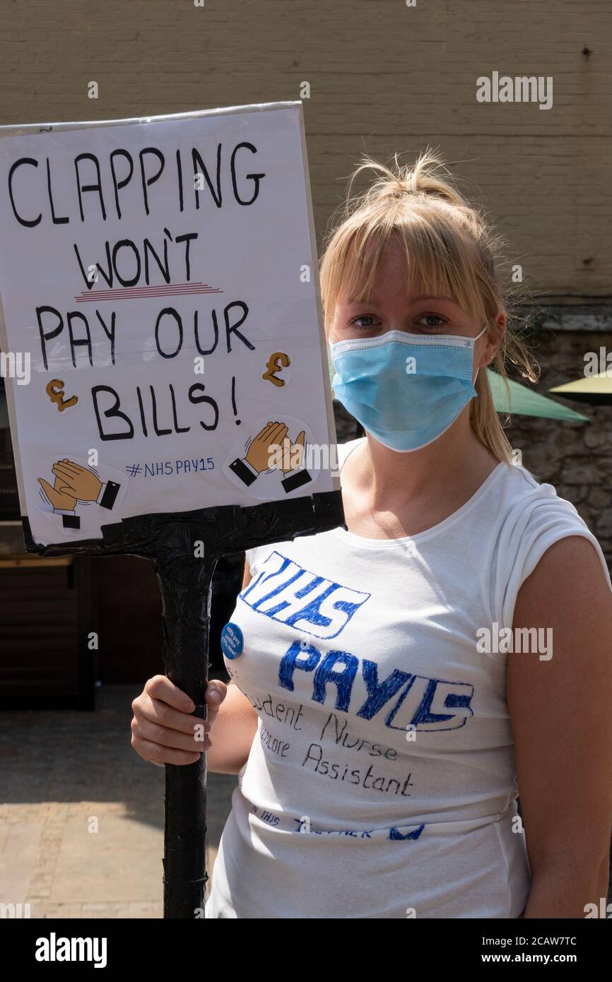 Oxford, UK. 8th August 2020. NHS workers and supporters attended a rally in Oxford’s Bonn Square calling for pay justice for all NHS workers, protesting to demand a pay rise to reflect their efforts during the covid pandemic This was one of around 38 similar rallies held throughout the UK. The protestors maintained social distancing and wore masks. While listening to speakers many held placards that highlighted their grievances and how they felt under valued. Pictured, NHS worker holding placard - Clapping Won't Pay Our Bills #NHSPAY15. Credit: Stephen Bell/Alamy Stock Photo