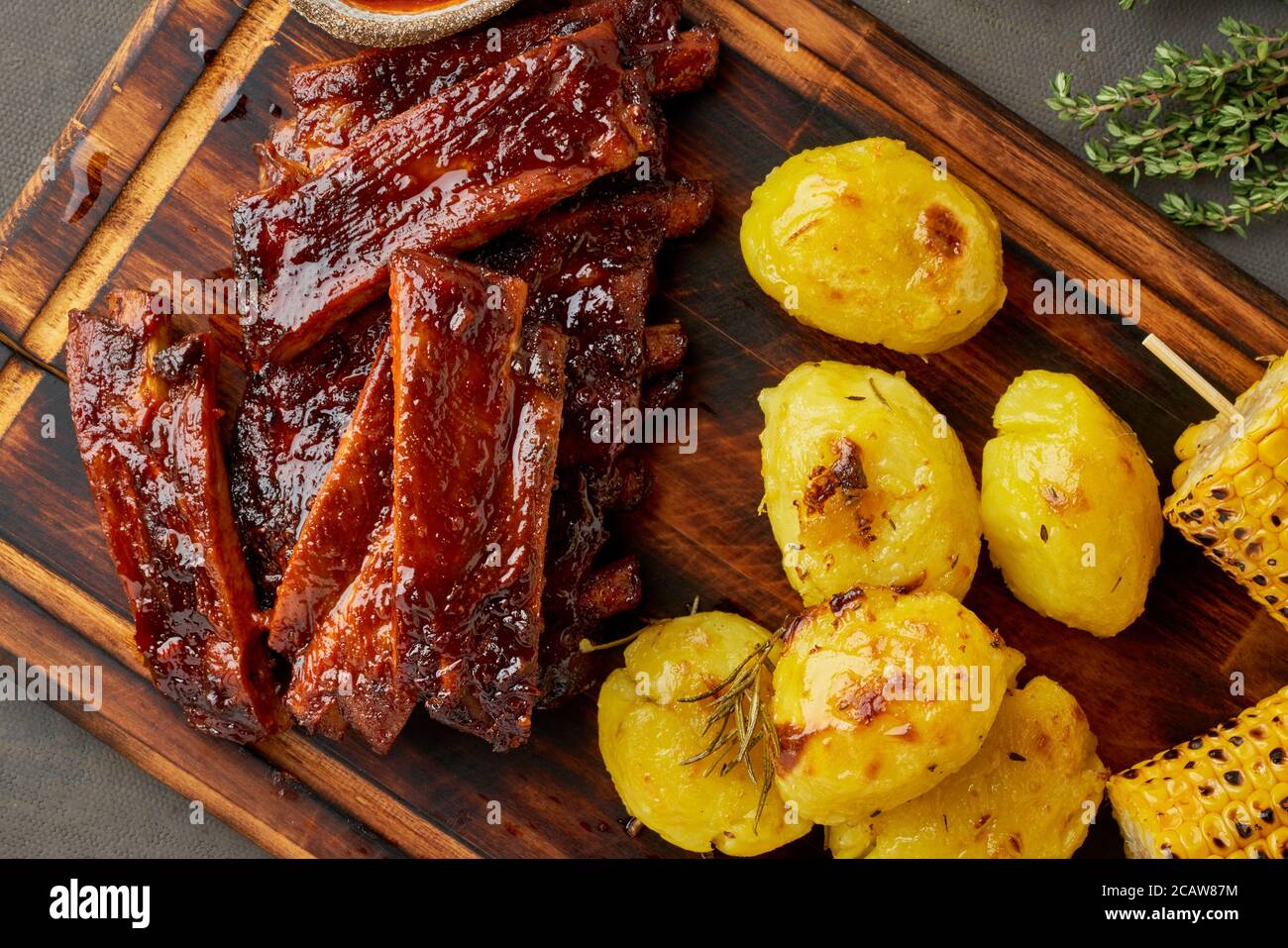 Spicy barbecue pork ribs, corn ears and crushed smashed potatoes. Slow